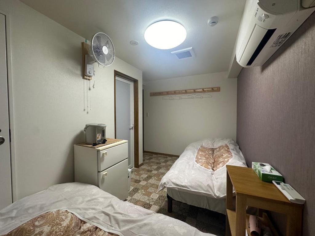 Postel nebo postele na pokoji v ubytování 駅本ビル民宿