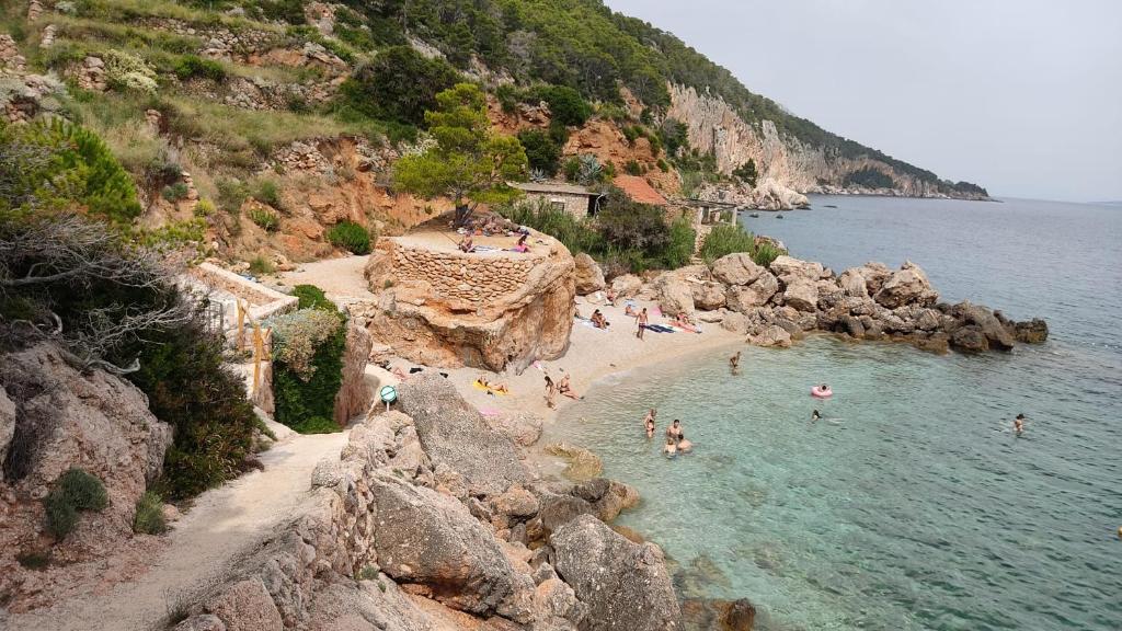 a group of people on a beach in the water at Apartments Villa Ypsilon in Sveta Nedelja