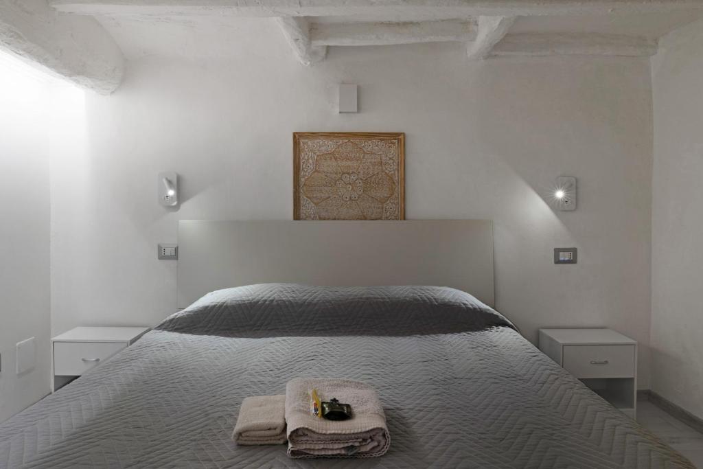a white bedroom with a bed with towels on it at Casa Cartoleria 34 in Bologna