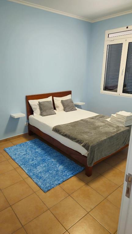 a bedroom with a bed and a blue wall at Funchal Apartments - New Botanic Garden Petit Studios in Funchal