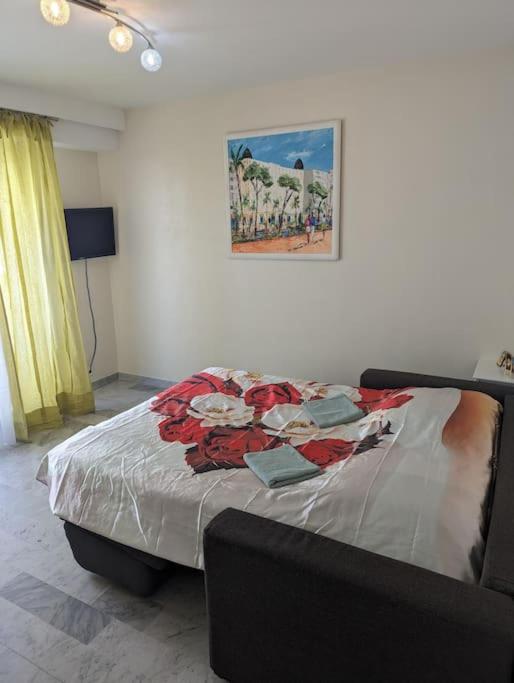 - un lit dans une chambre avec une photo sur le mur dans l'établissement Charmant T1 au cœur de Nice, à Nice