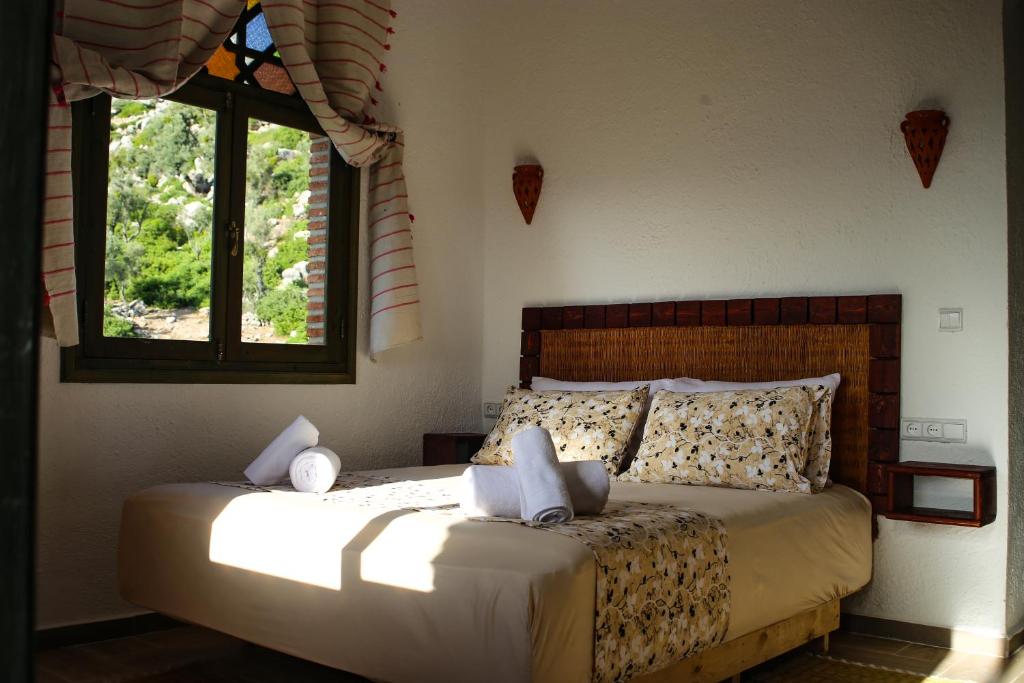 1 dormitorio con 1 cama en una habitación con 2 ventanas en Haven Hills Social Club, en Chefchaouen