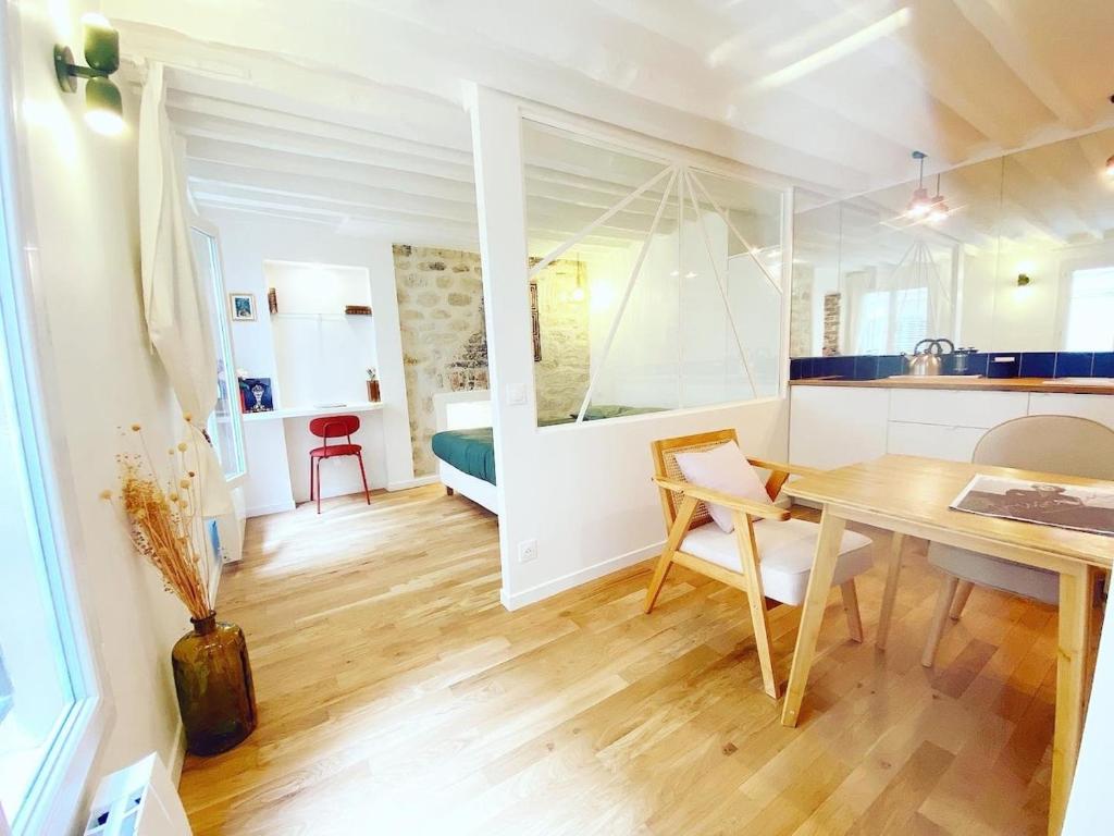 une cuisine et une salle à manger avec une table et une chambre dans l'établissement Charmant appartement a Paris - FLAT-GUEST, à Paris