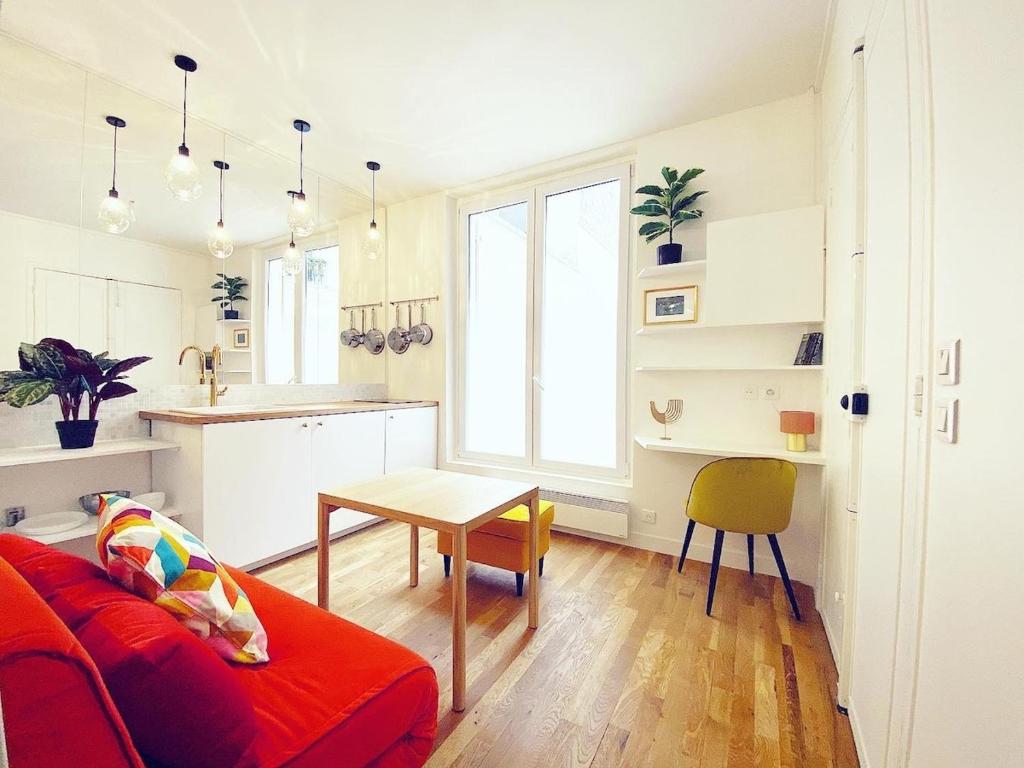 un salon avec un canapé rouge et une table dans l'établissement Tres bel appartement au coeur de Paris - FLAT-GUEST, à Paris