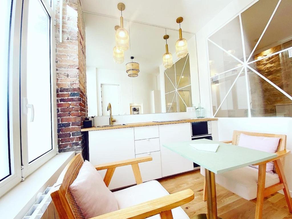 une cuisine avec une table blanche et un mur en briques dans l'établissement Magnifique appartement a Paris - FLAT-GUEST, à Paris