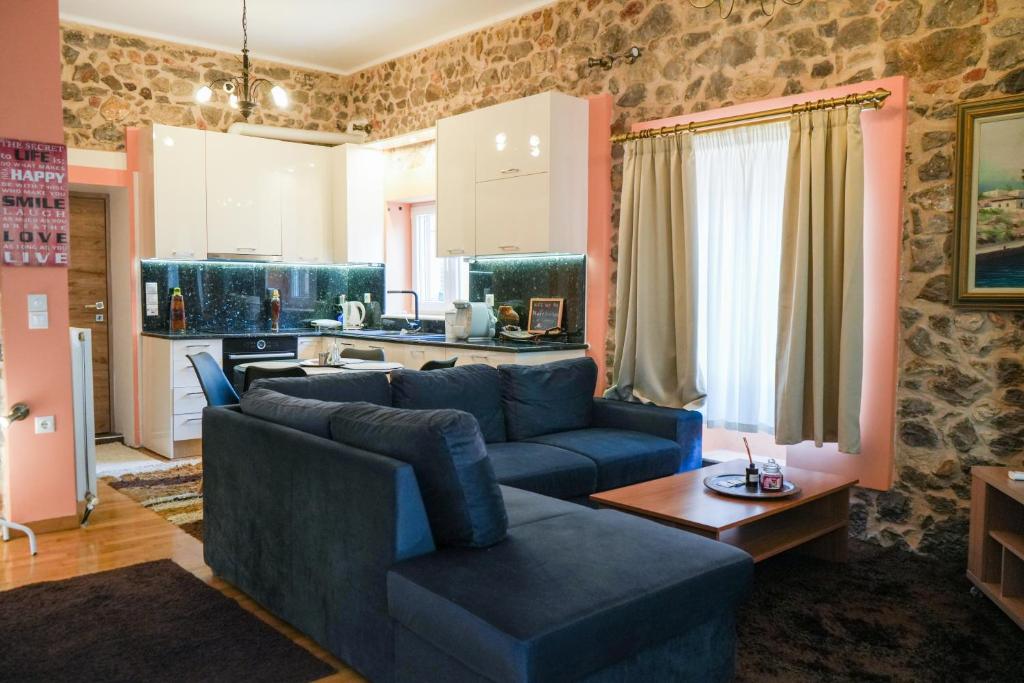 a living room with a blue couch and a kitchen at Φιλόξενο Σπίτι in Nafplio
