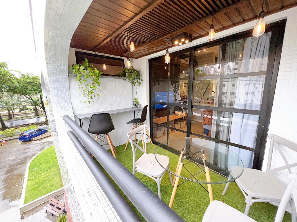 a balcony with chairs and a table on a building at Flat Manhattan frente ao Dona Lindu in Recife