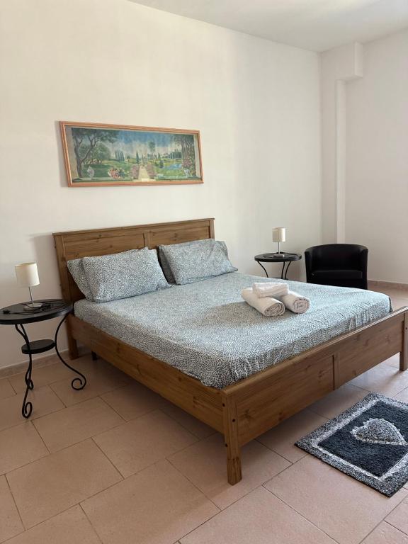 1 dormitorio con 1 cama grande de madera y 2 mesas en Casa Stella del Vesuvio, en Portici