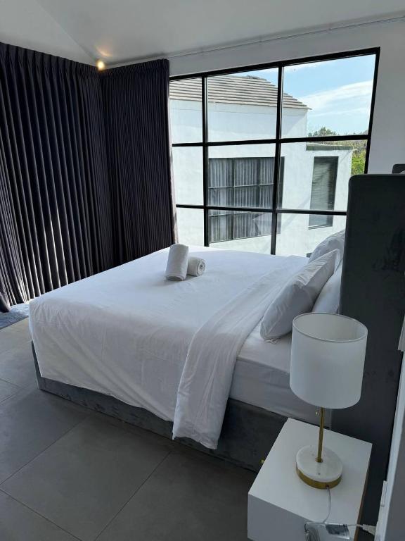 a bedroom with a white bed and a large window at Villa Valeria in Ungasan
