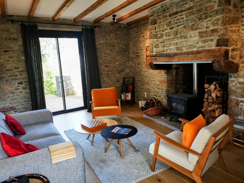 un salon avec un canapé et une cheminée dans l'établissement Le Chant des Oiseaux, à Saint-Pair-sur-Mer