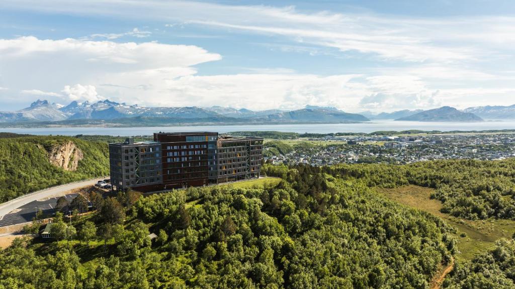 an aerial view of a building on a hill with trees at Wood Hotel Bodø in Bodø