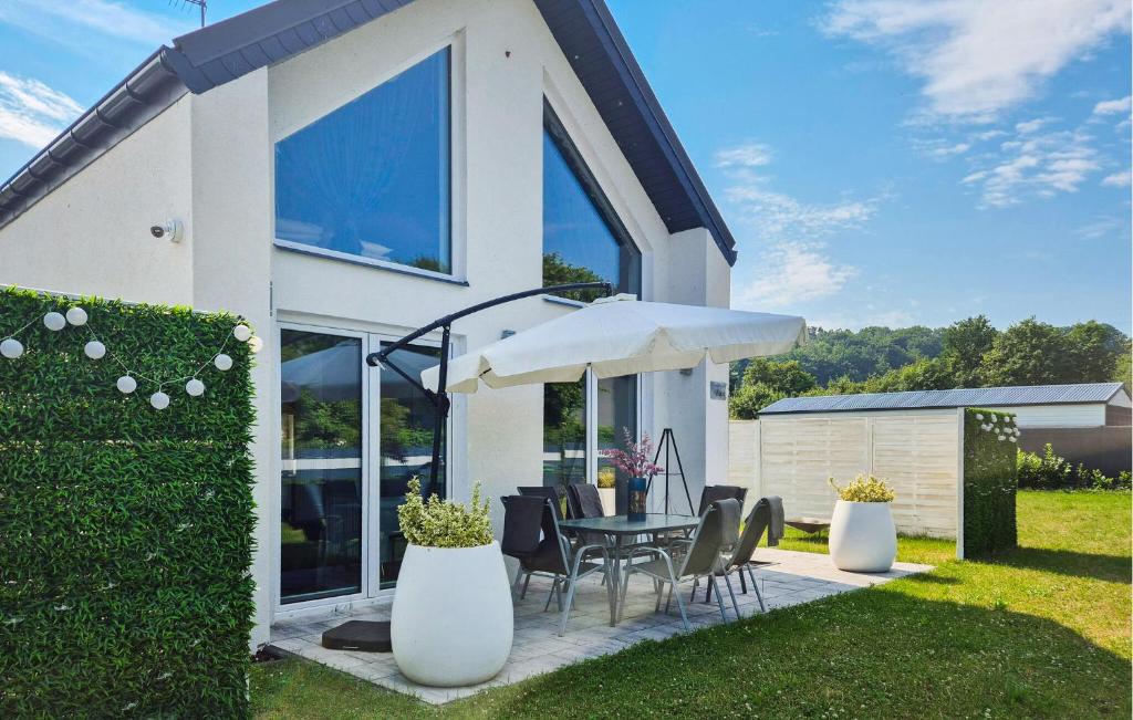 una casa con mesa, sillas y sombrilla en 3 Bedroom Nice Home In Wapnica, en Wapnica