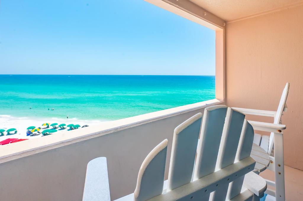 a view of the beach from a balcony with a beach chair at The Surf Shack in Destin