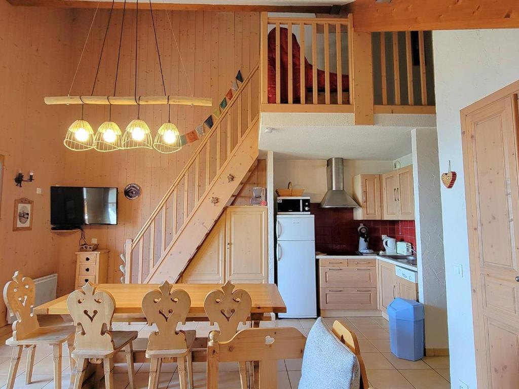 une cuisine avec une table à manger et un escalier dans l'établissement Appartement Duplex 7p - Balcon Sud - Cheminée - WiFi - Parking - Animaux admis - FR-1-393-121, à Saint-Michel-de-Chaillol