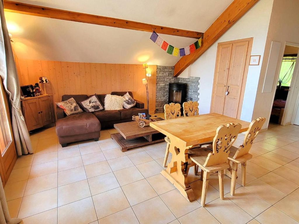 un salon avec une table et un canapé dans l'établissement Charmant Duplex à Chaillol avec Balcon Sud, WIFI et Parking Optionnel, Capacité 5 Personnes - FR-1-393-14, à Saint-Michel-de-Chaillol