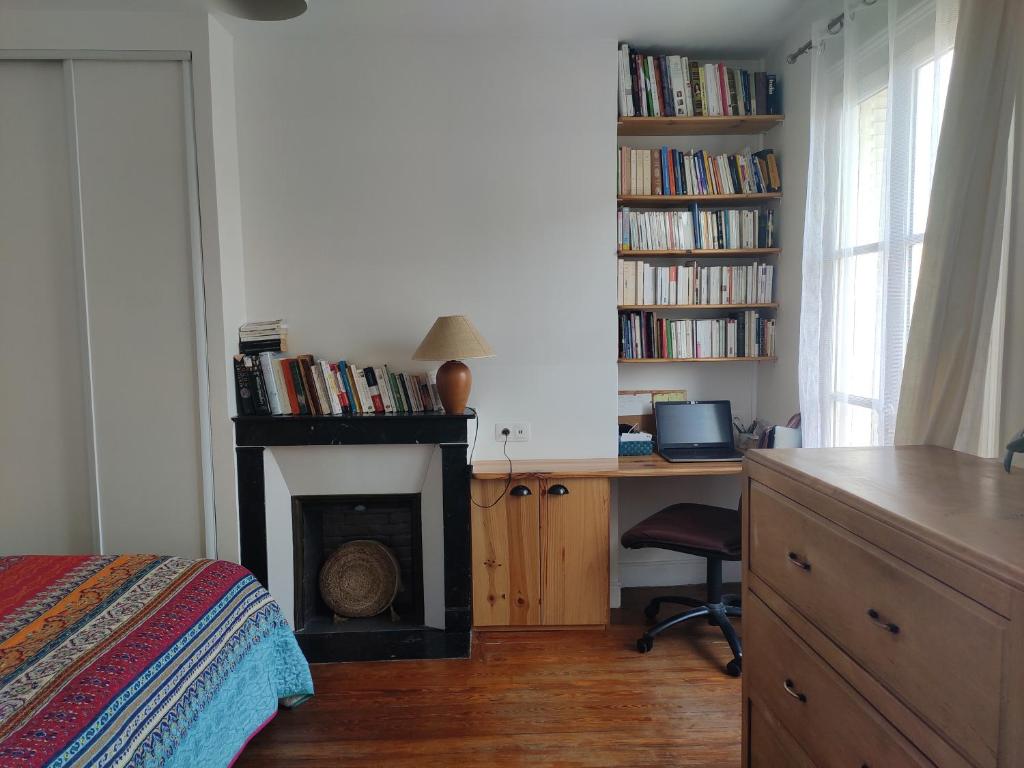 une chambre avec un bureau et une cheminée et un bureau avec un ordinateur dans l'établissement Yogapart, au Kremlin-Bicêtre