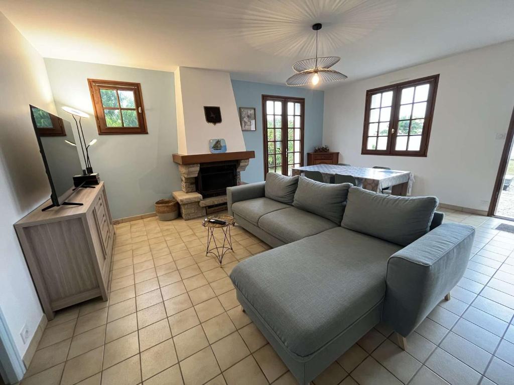un salon avec un canapé et une télévision dans l'établissement Jolie villa rénovée, 900m plage, jardin clos, animaux admis, parking, balades corniche vendéenne - FR-1-324-565, à Saint-Hilaire-de-Riez