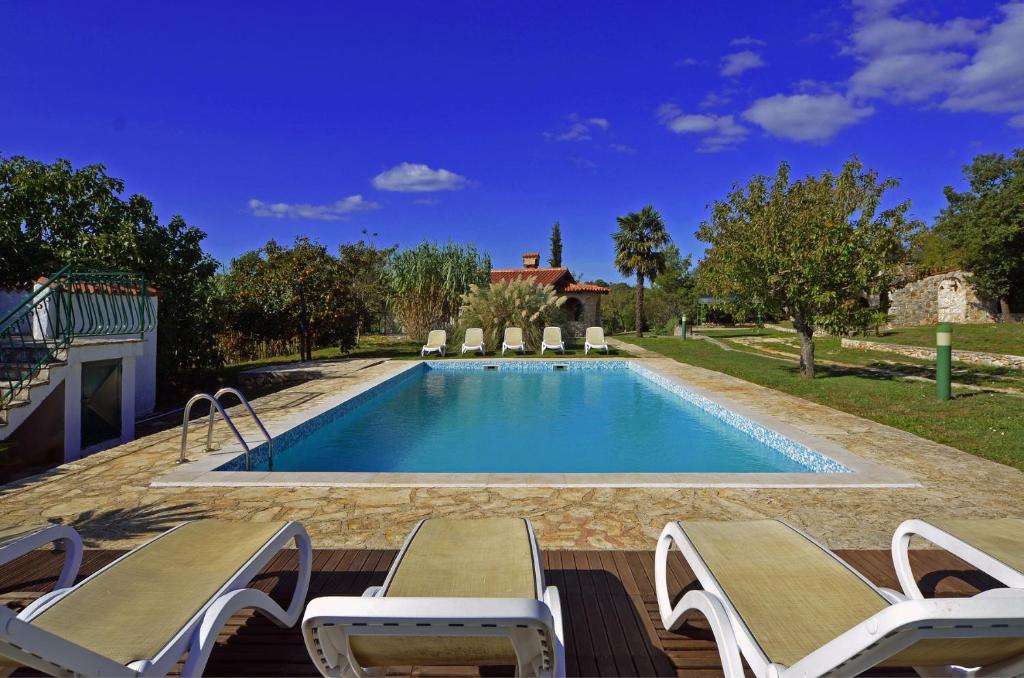 a swimming pool with two lounge chairs and a house at Holiday Home Campo in Rovinj