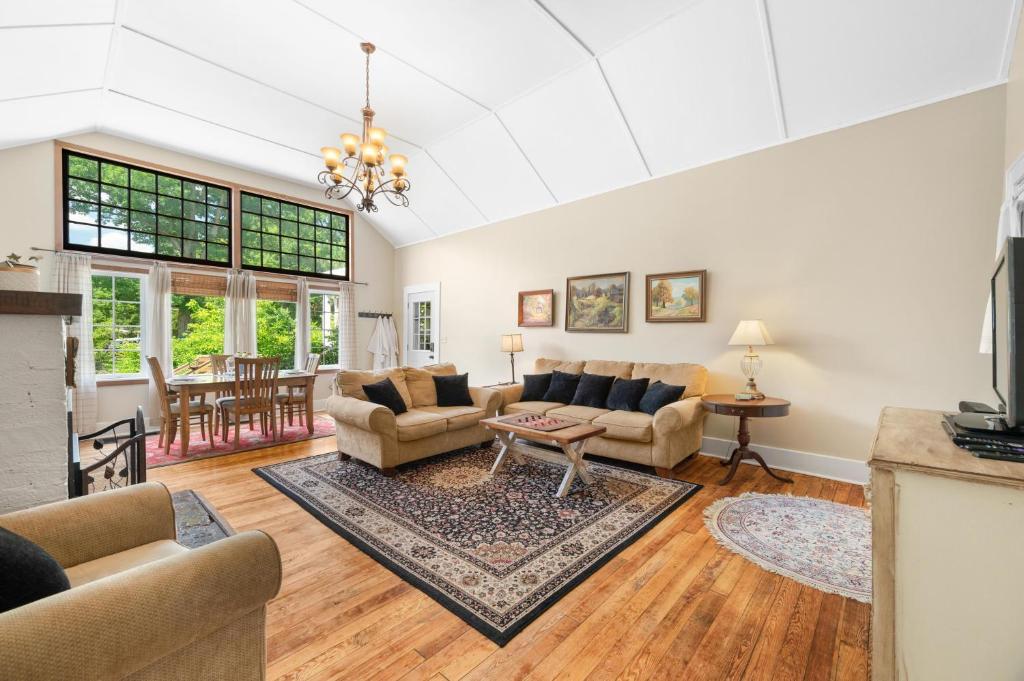 a living room with couches and a table at Artist Lane Cottage in Nashville