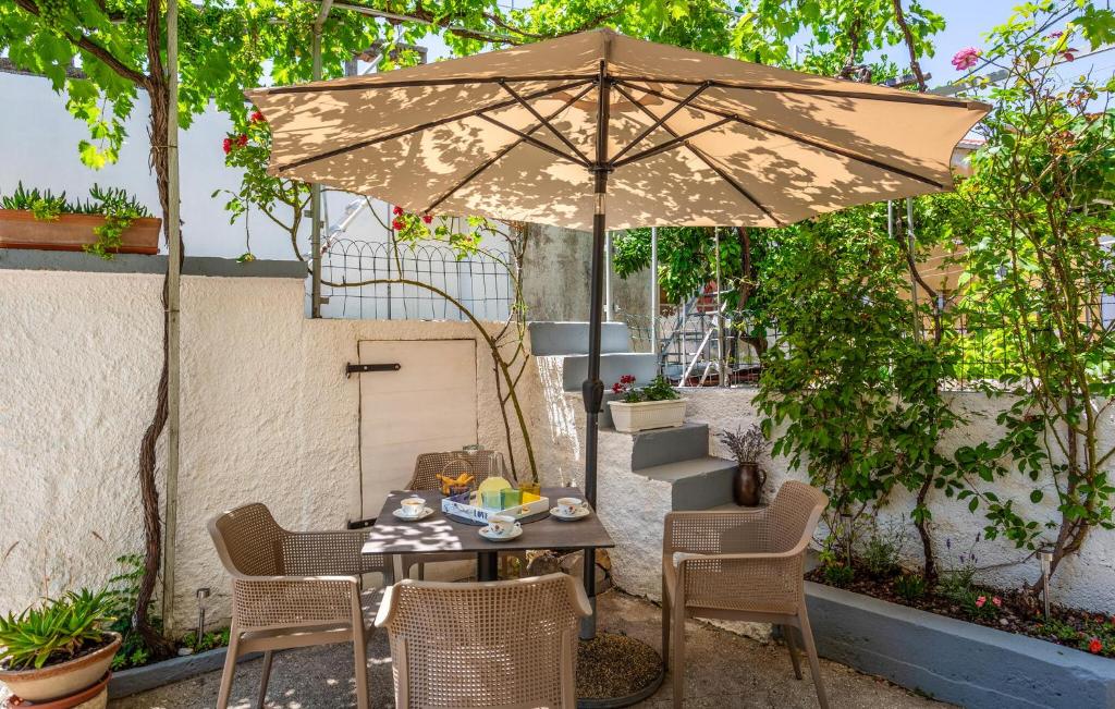 プナトにあるNice Apartment In Punatのパティオ(パラソルの下にテーブルと椅子付)