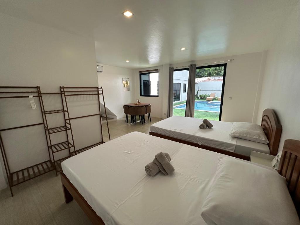 プエルト・プリンセサにあるKasamigos Guesthouse with Fast Internetのベッド2台、テーブルが備わる客室です。