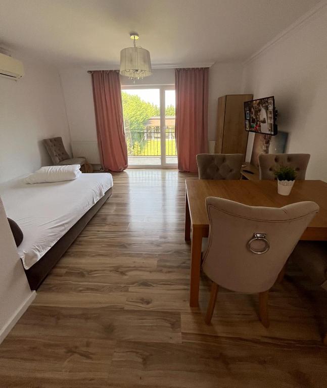 a bedroom with a bed and a desk and a table at Armonia Apartments in Timişoara