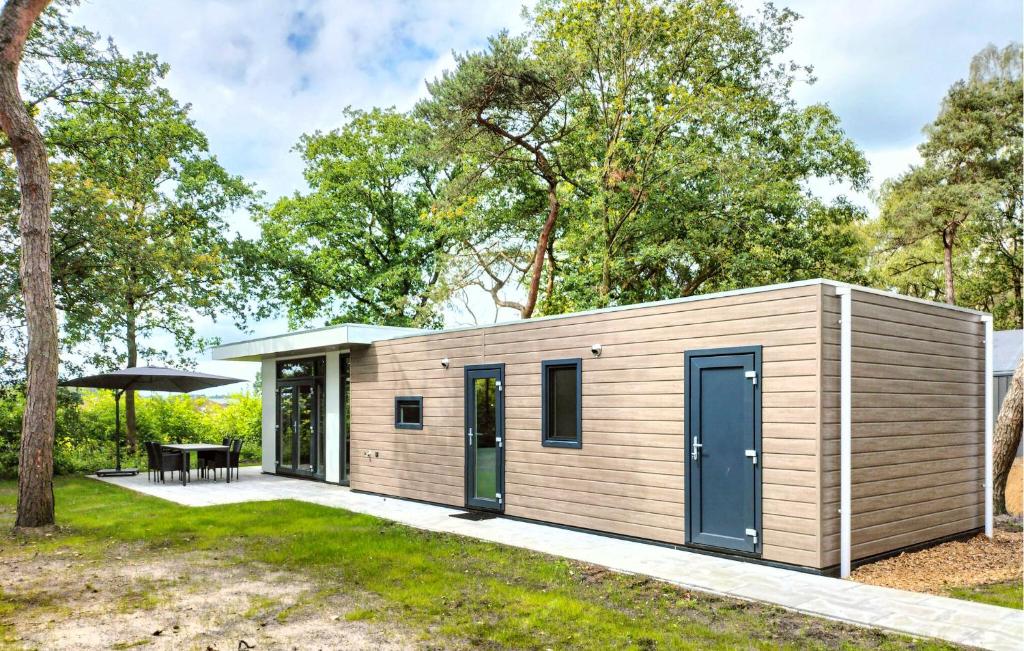 a small cabin with a blue door in a yard at 2 Bedroom Nice Home In Hellendoorn in Hellendoorn