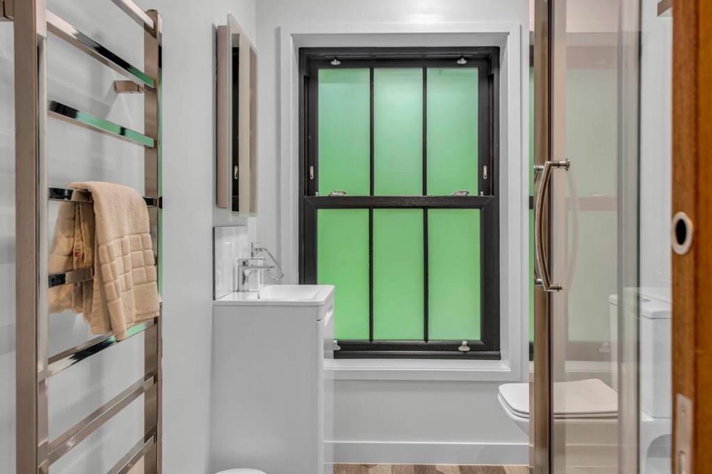 a bathroom with a green window and a sink at Pass the Keys Larkey View a Tranquil Space for Two in Chartham
