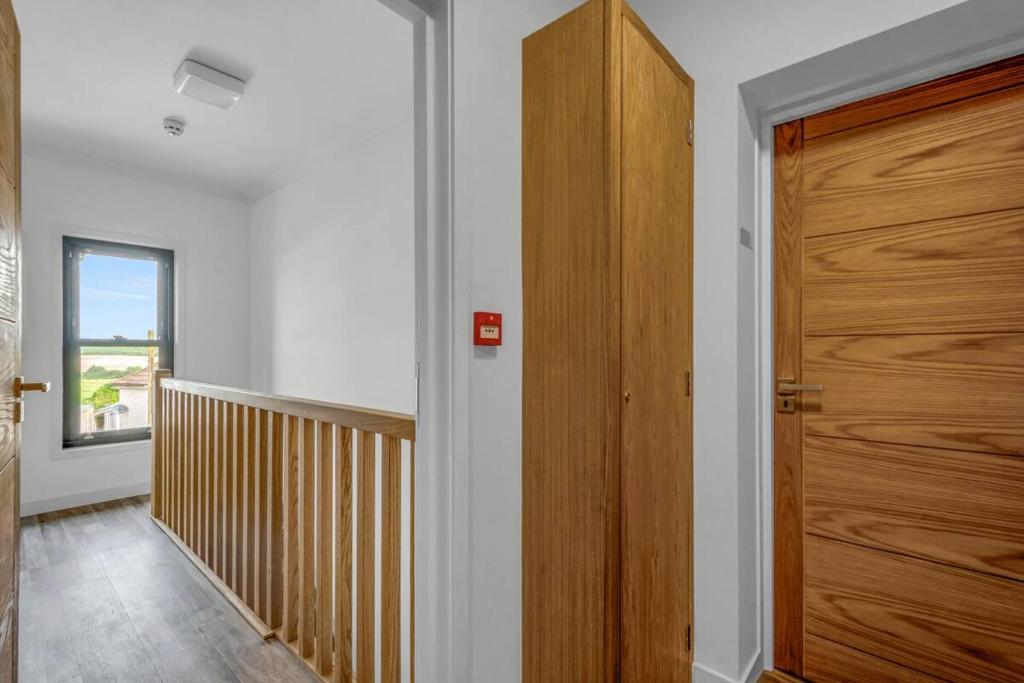 a hallway with a wooden door in a house at Pass the Keys Larkey View a Tranquil Space for Two in Chartham