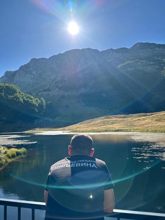 a man sitting on a boat looking at a lake at Apartman Cicović in Foča