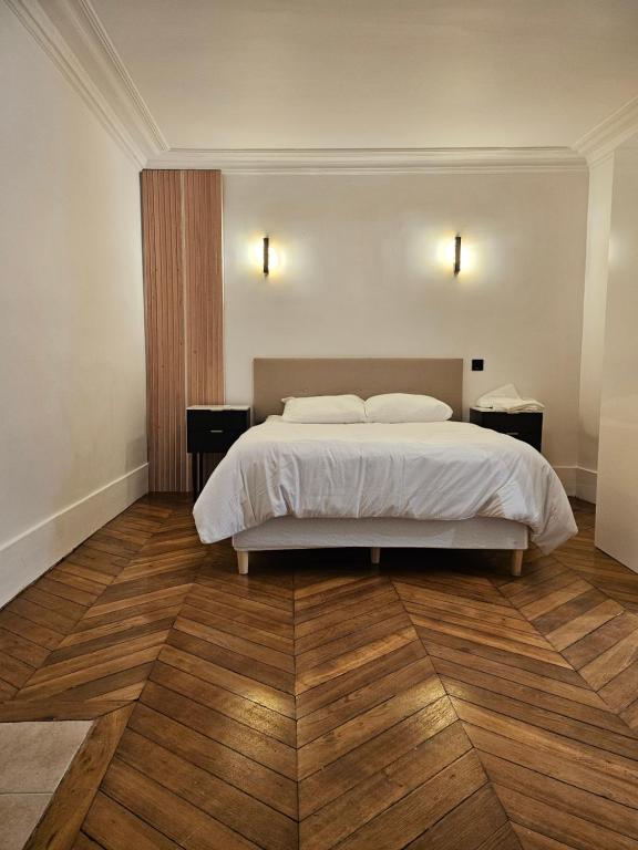- une chambre avec un lit blanc et du parquet dans l'établissement Highstay Champs Elysées ARC de triomphe, à Paris