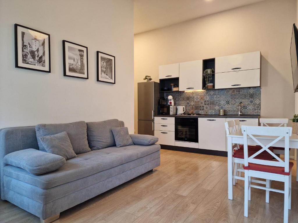 Una sala de estar con un sofá y una cocina. en Apartman Golf, en Zagreb