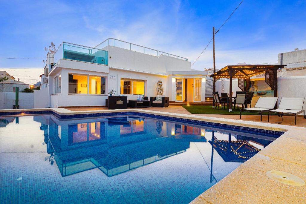 a villa with a swimming pool in front of a house at Casablanca Spaniahome in L’Alfàs del Pi