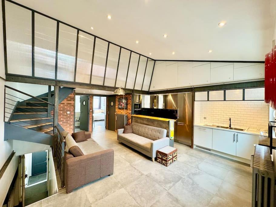 Il comprend un grand salon avec un canapé et une cuisine. dans l'établissement A l Urban de Champagne - Reims, à Reims