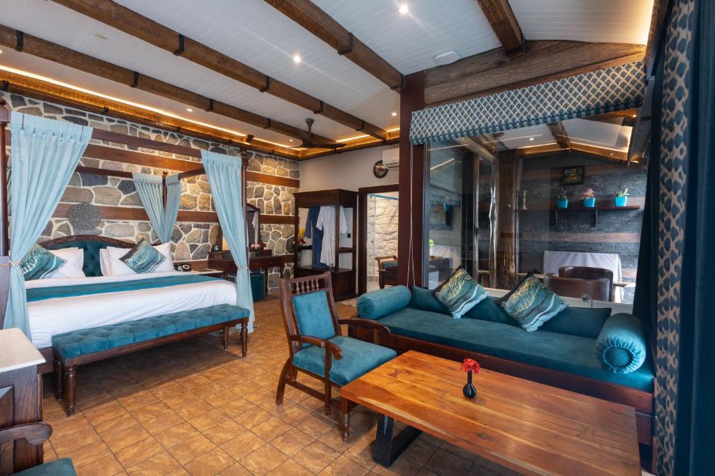 a bedroom with a bed and a couch and a table at Jharipani Castle in Mussoorie