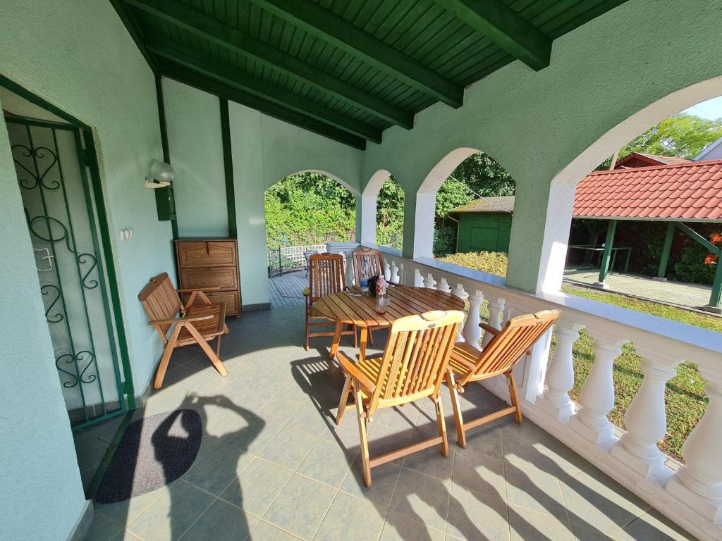 a porch with chairs and a table on a balcony at Zöldház in Balatonmáriafürdő