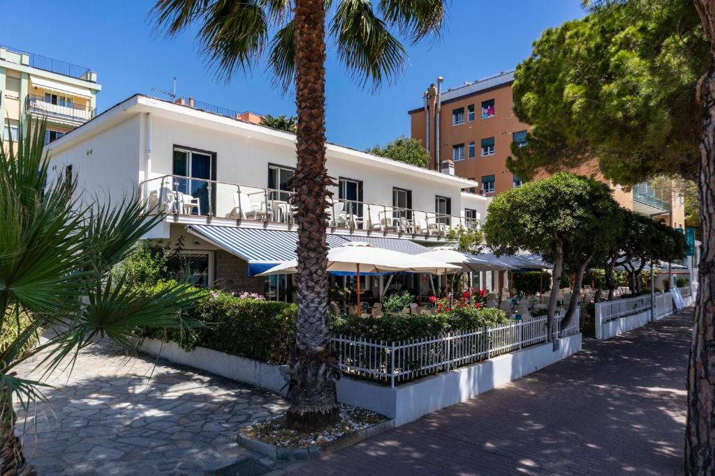biały budynek z palmami przed nim w obiekcie Piccolo hotel le Palme w mieście San Bartolomeo al Mare
