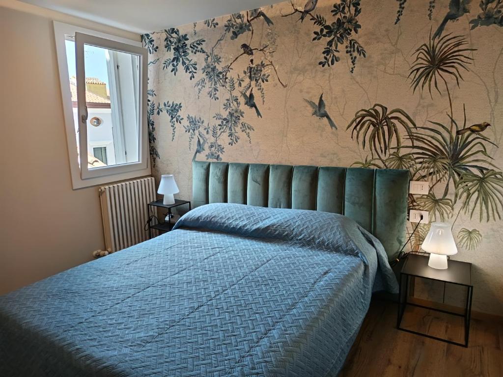 a bedroom with a bed with a blue comforter at La Scarpa della Strega in Chioggia