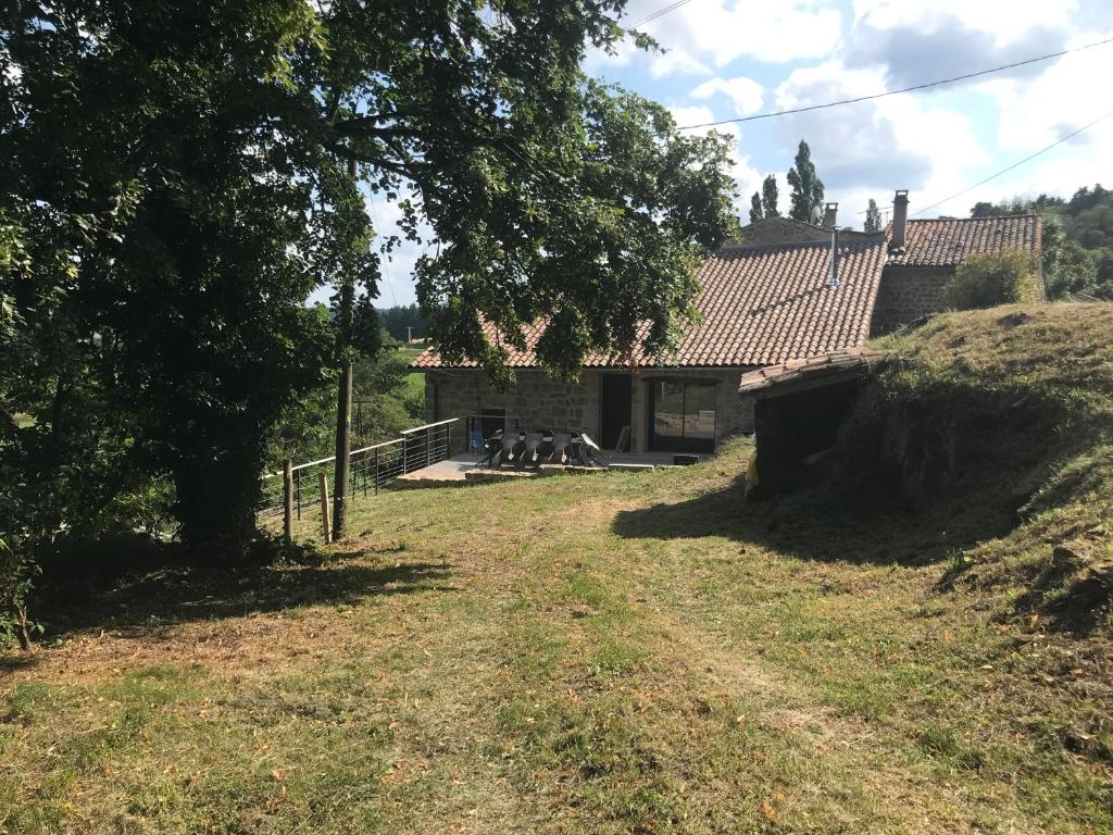 une maison avec une cour devant un bâtiment dans l'établissement Gîte 10 personnes Ardèche Jacuzzi, à Saint-Apollinaire-de-Rias