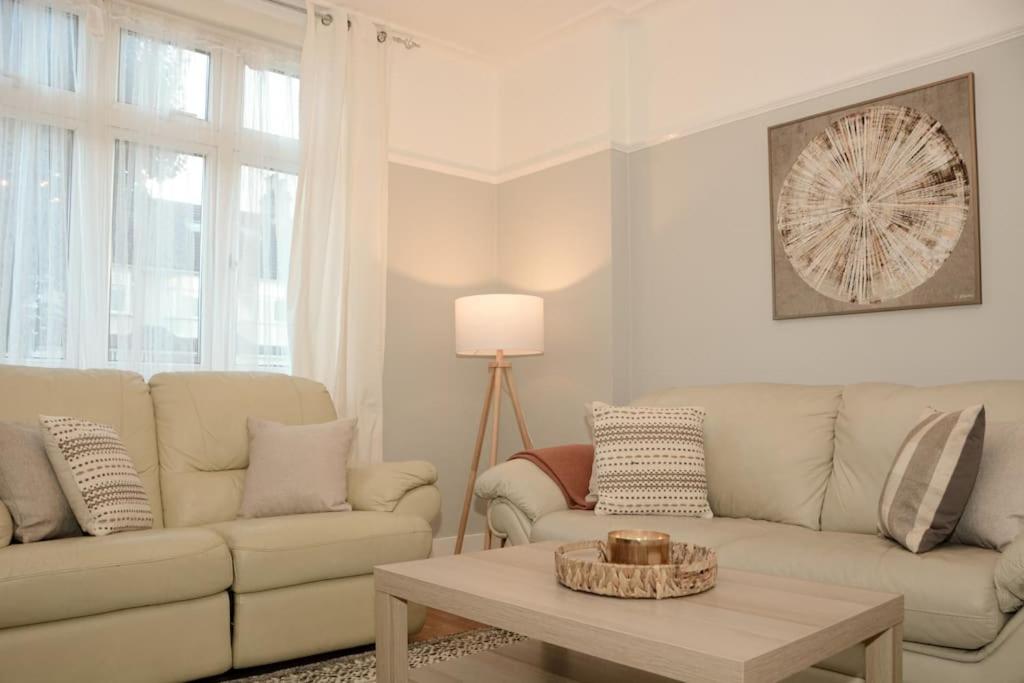 ロンドンにある3 Bed House in the heart of Palmers Green, Londonのソファとテーブルのあるリビングルーム