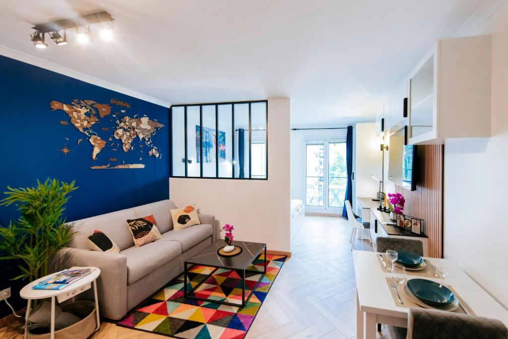 un soggiorno con divano e parete blu di Paris Porte de Versailles - ISSYHOST a Issy-les-Moulineaux