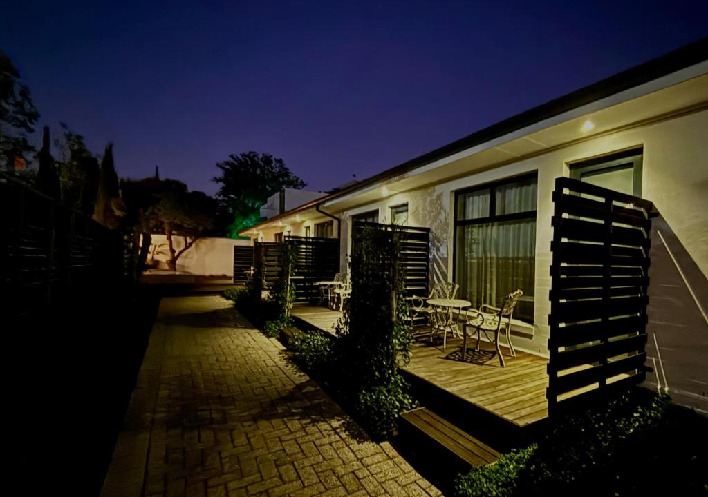 a patio with a table and chairs next to a building at Blix Inn Guesthouse in Stellenbosch