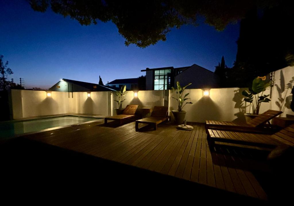 a deck with chairs and lights on a house at night at Blix Inn Guesthouse in Stellenbosch