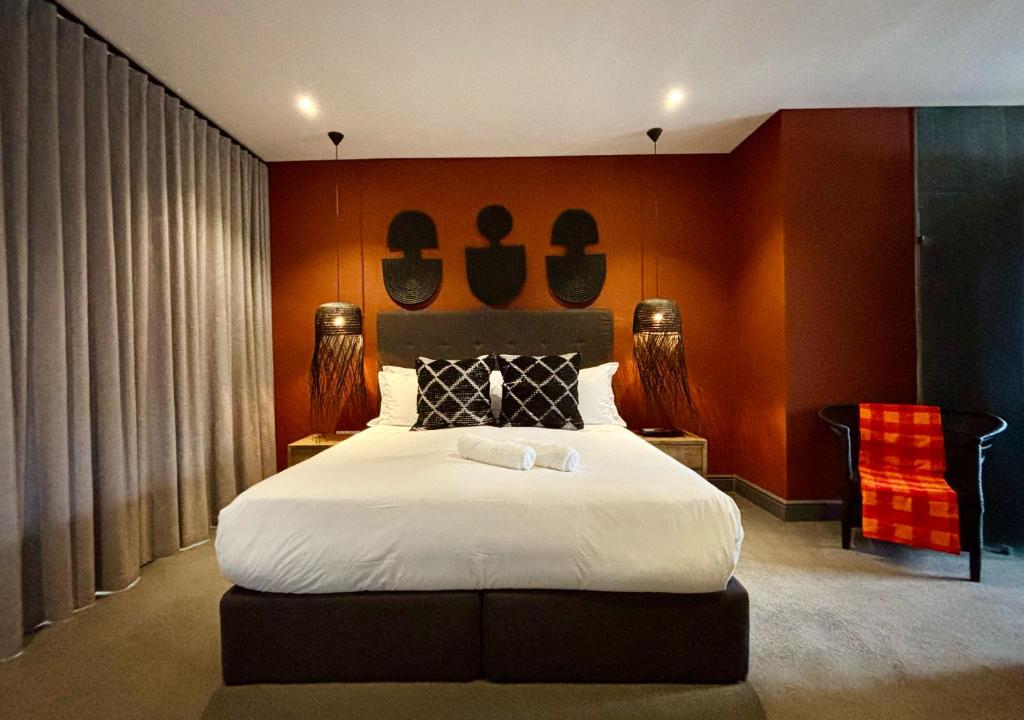 a bedroom with a large bed and a red wall at Blix Inn Guesthouse in Stellenbosch