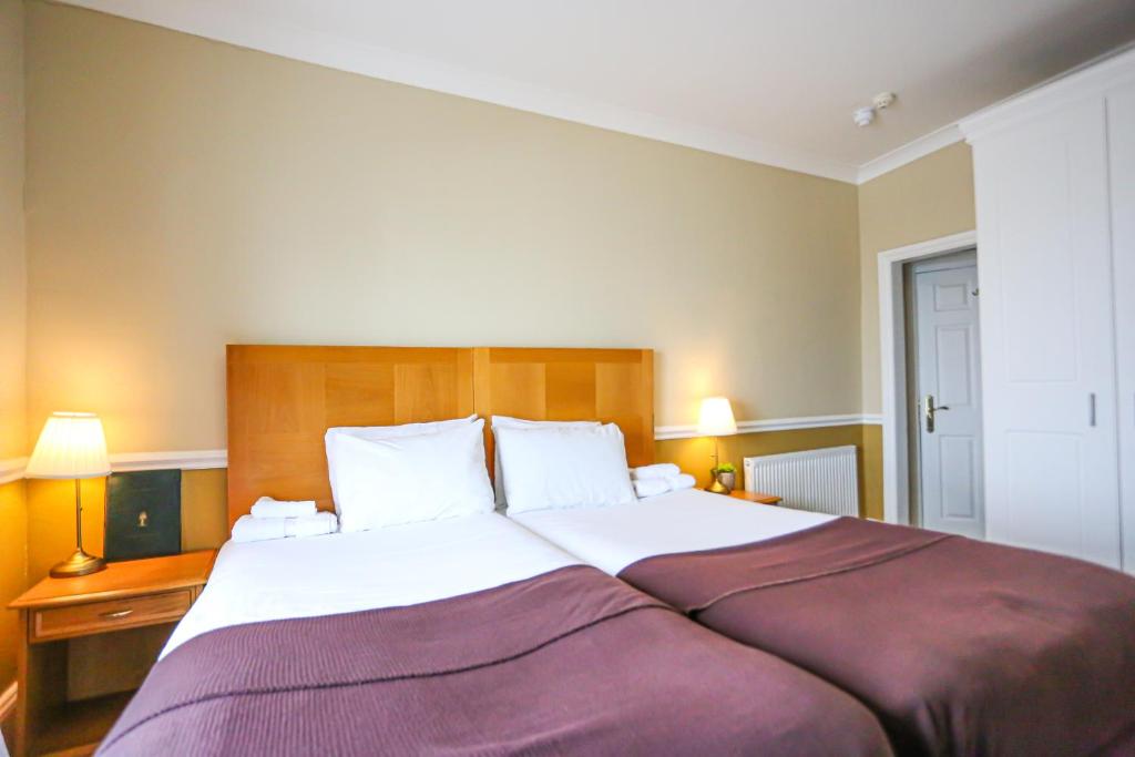 a bedroom with a large bed with a purple blanket at The Wellington Hotel in Ventnor
