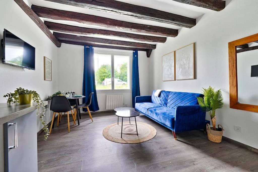 a living room with a blue couch and a table at Welcome to Clara House in Wissous
