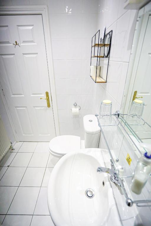 a white bathroom with a sink and a toilet at The Wellington Hotel in Ventnor