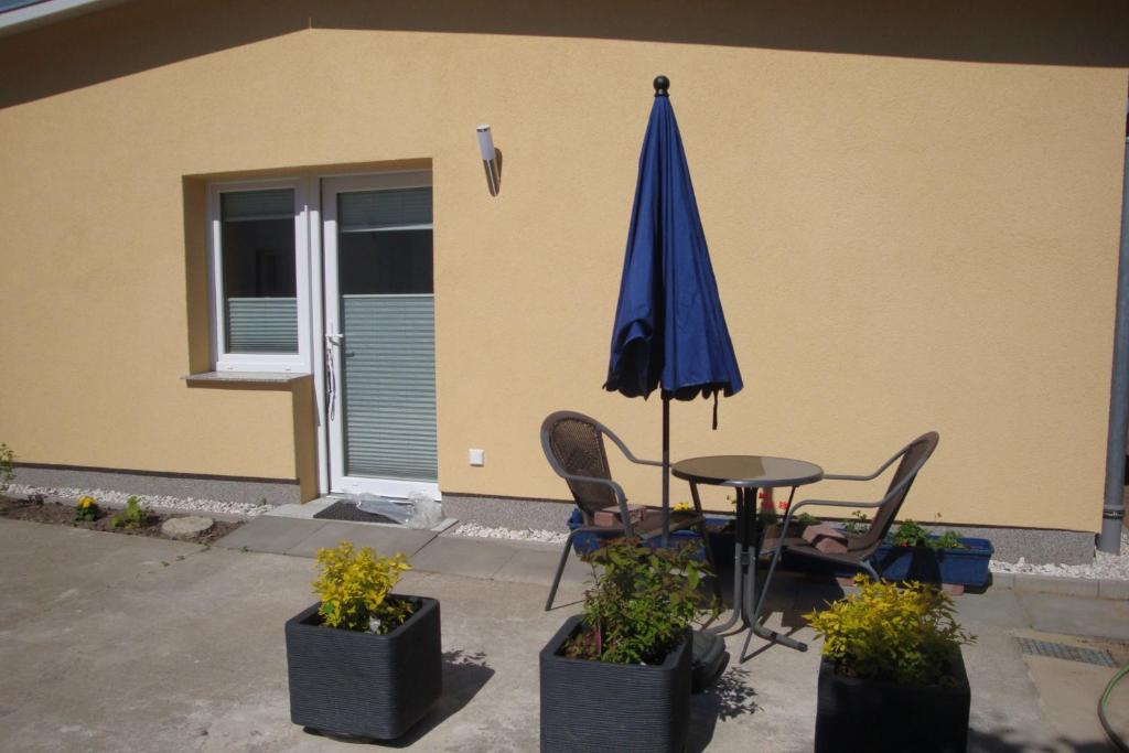 a table with a blue umbrella and two chairs and a table at Ferienquartier Trassenheide 1 in Trassenheide