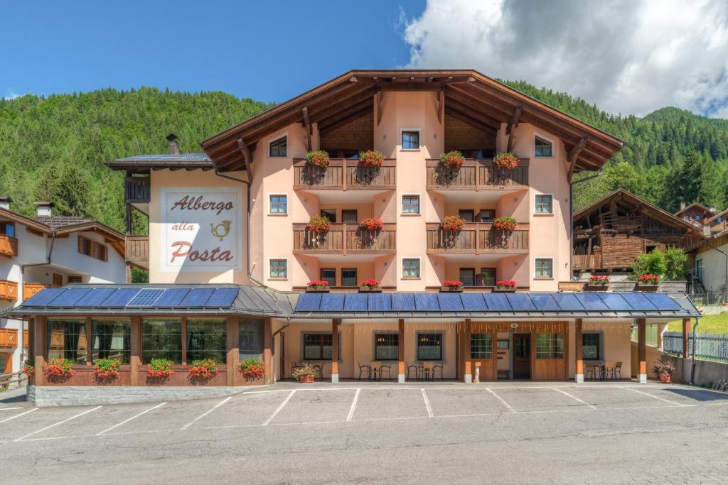 マドンナ・ディ・カンピリオにあるAlbergo alla Postaのホテルの正面に駐車場があります。