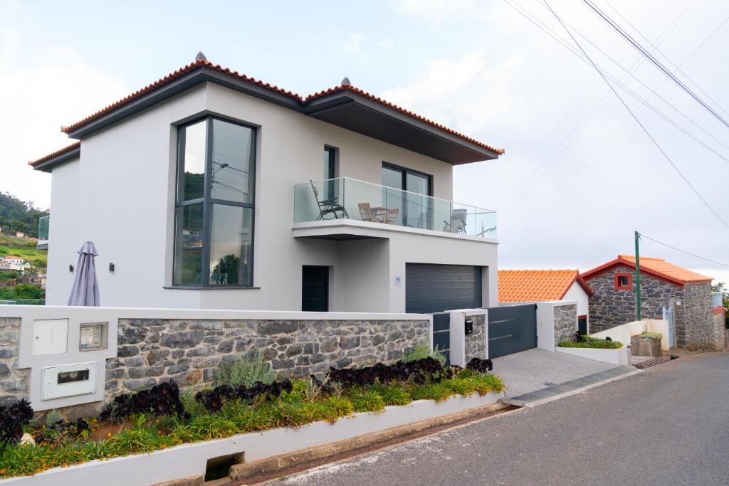 une maison blanche avec un mur en pierre dans l'établissement Paradise views - Pereira House, à Arco da Calheta
